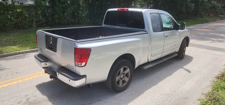Rear passenger-side view showing the Titan bed and body wear